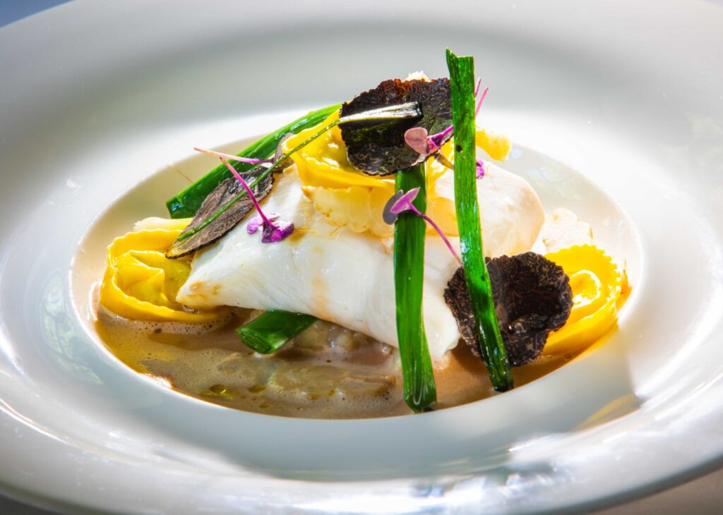 Poached Fillet Of Turbot With Baby Leeks Truffle And Potato Tortellini And Truffle Veloute